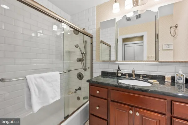 a bathroom with a tub sink and mirror