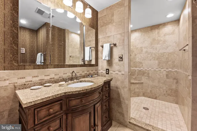 a bathroom with a sink a toilet a shower and a mirror