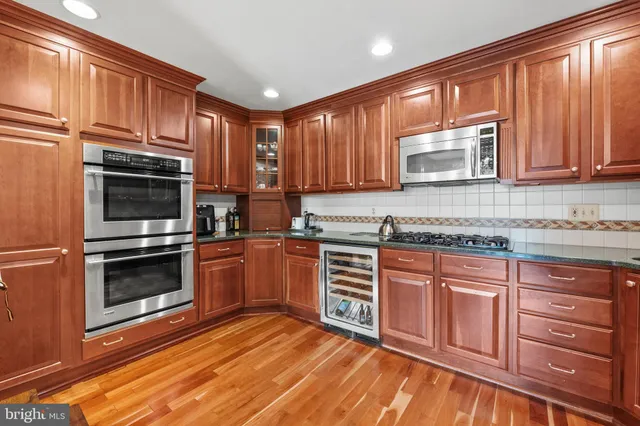 a kitchen with granite countertop wooden cabinets stainless steel appliances and a window