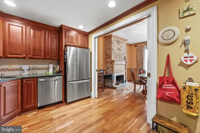 a kitchen with stainless steel appliances granite countertop a refrigerator stove top oven and wooden floor