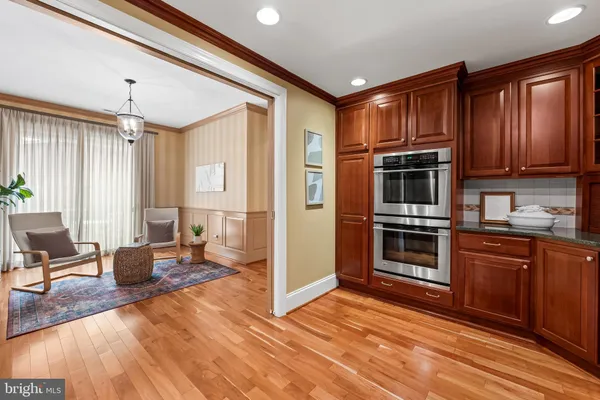 a large kitchen with stainless steel appliances granite countertop a stove a sink and dishwasher wooden cabinets with wooden floor