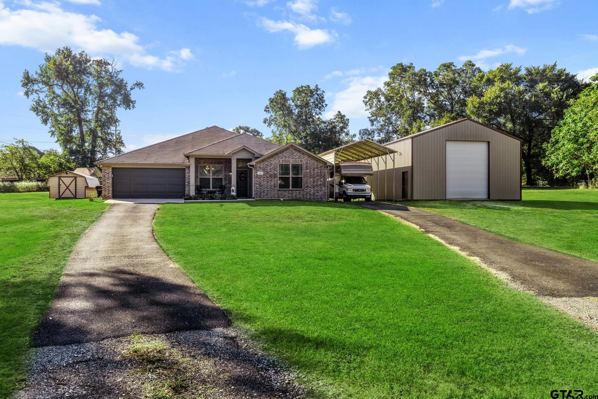 a front view of a house with a yard and trees