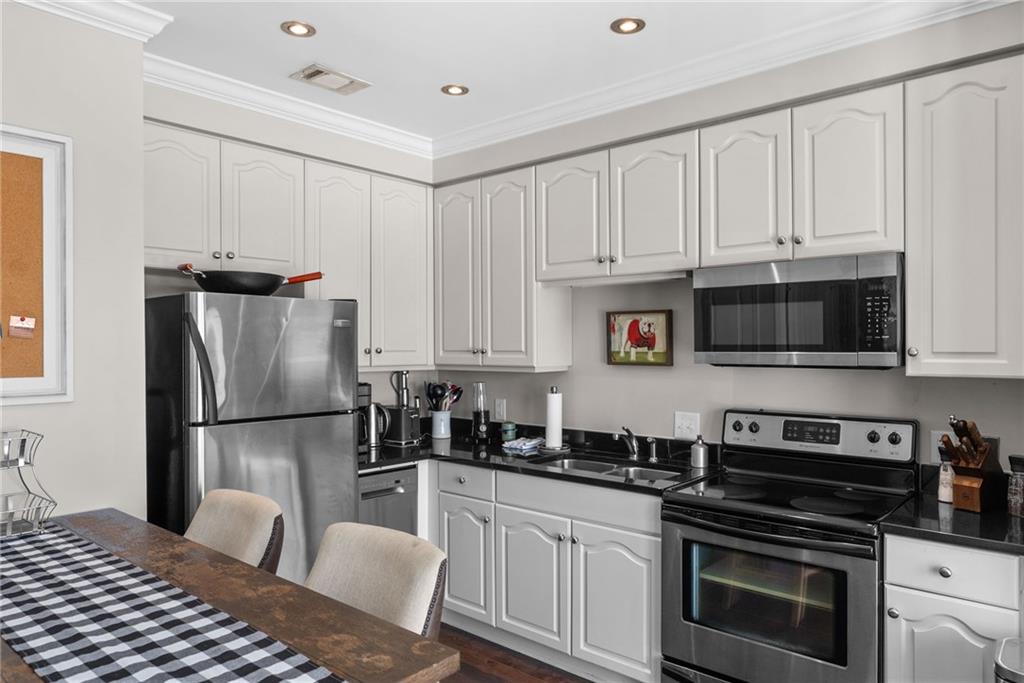 755 West Broad Street, Unit 820 Athens, GA 30601 - Photo 15 of 64 a kitchen with a refrigerator stove and white cabinets