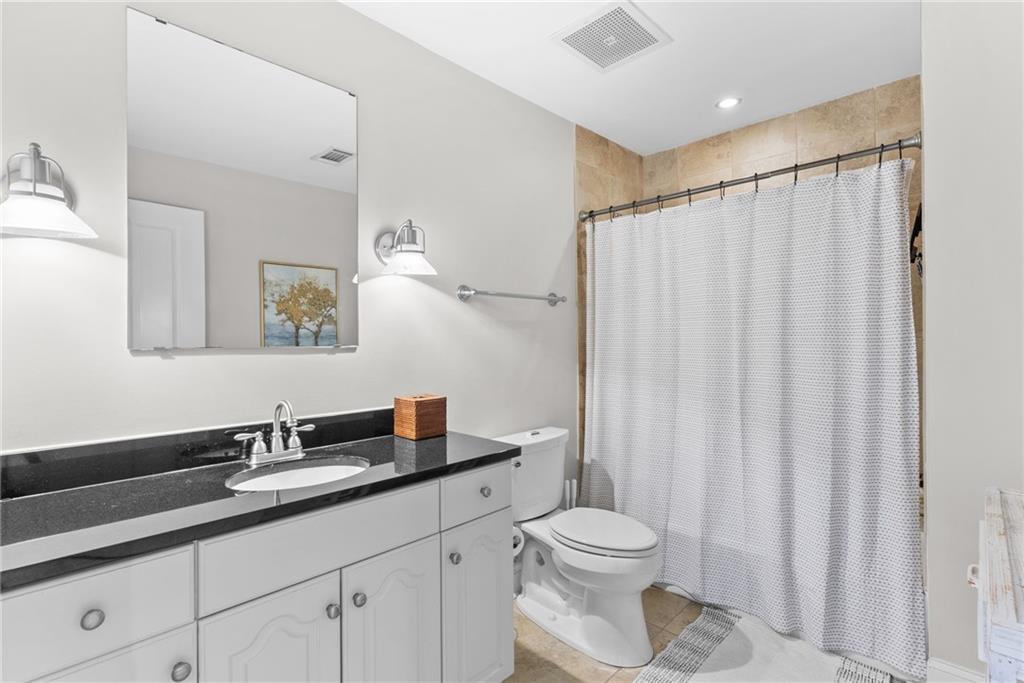 755 West Broad Street, Unit 820 Athens, GA 30601 - Photo 23 of 64 a bathroom with a granite countertop sink a toilet and a mirror