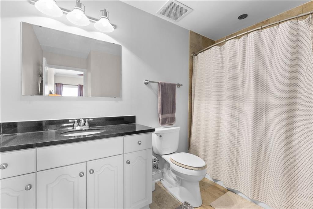 755 West Broad Street, Unit 820 Athens, GA 30601 - Photo 30 of 64 a bathroom with a granite countertop sink a toilet and a mirror