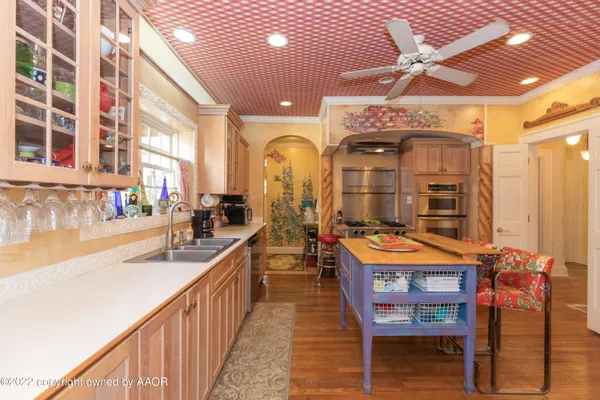 a kitchen with stainless steel appliances kitchen island granite countertop a sink and cabinets