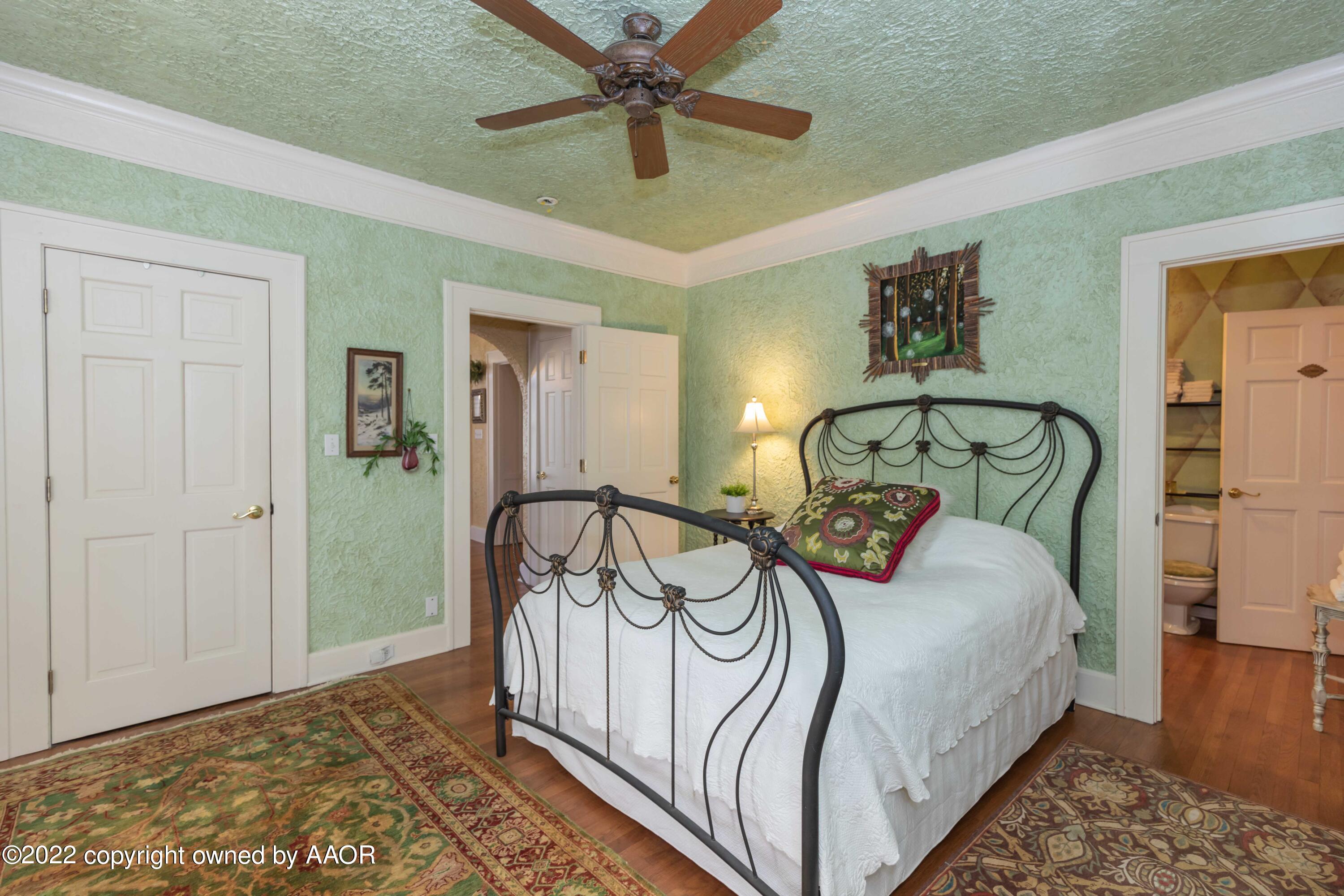 1607 South Harrison Street Amarillo, TX 79102 - Photo 25 of 71 a bedroom with a bed and a chandelier