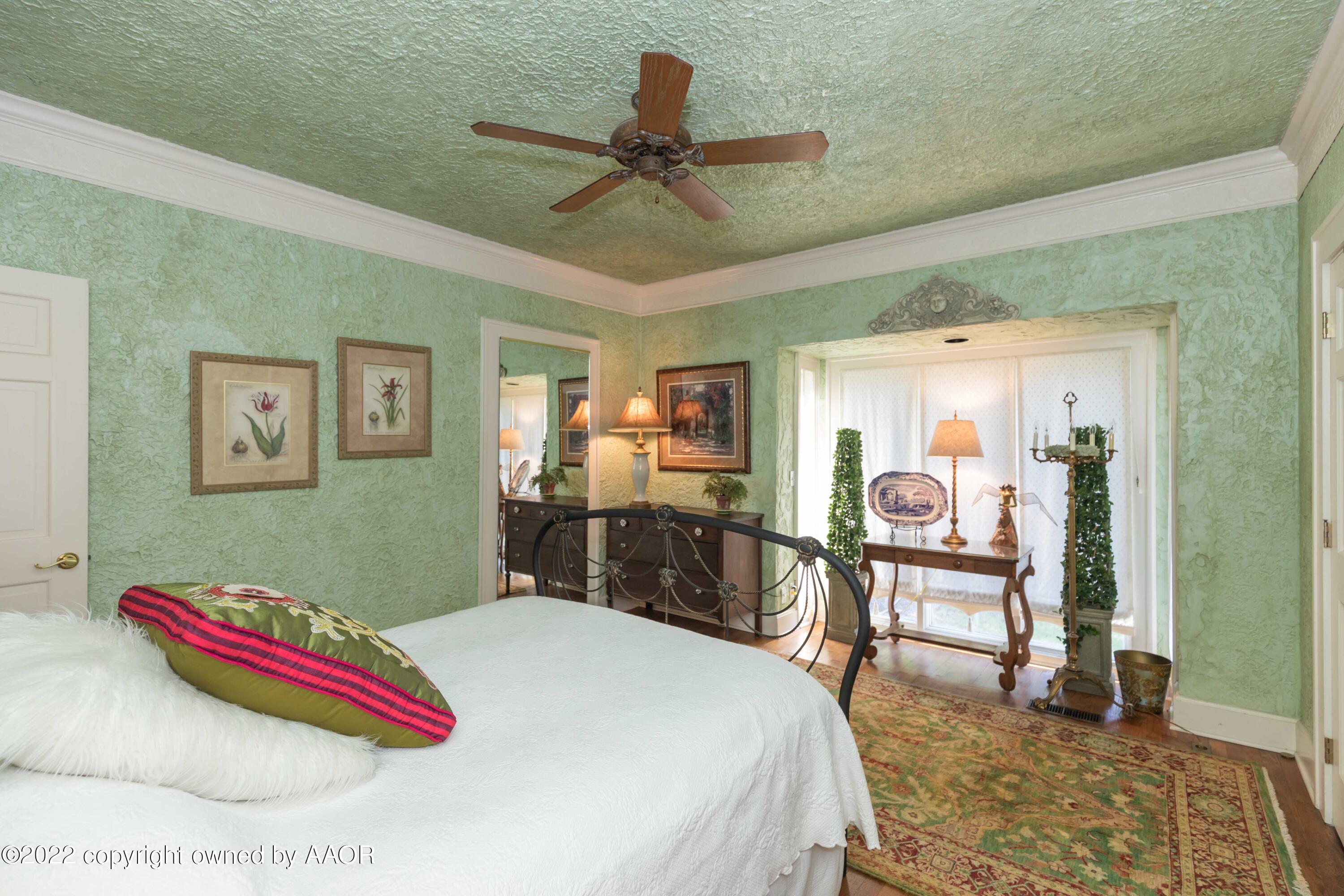 1607 South Harrison Street Amarillo, TX 79102 - Photo 26 of 71 a bedroom with a bed and a chandelier