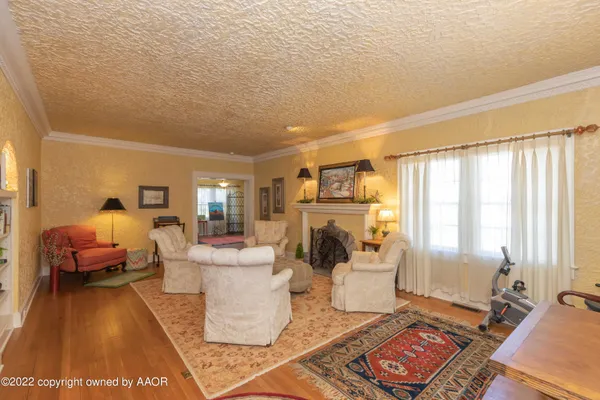 a living room with furniture a fireplace and a large window