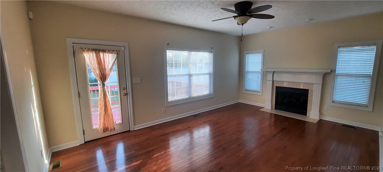 3513 Talus Road Fayetteville, NC 28306 - Photo 3 of 37 a view of an empty room with wooden floor fireplace and a window