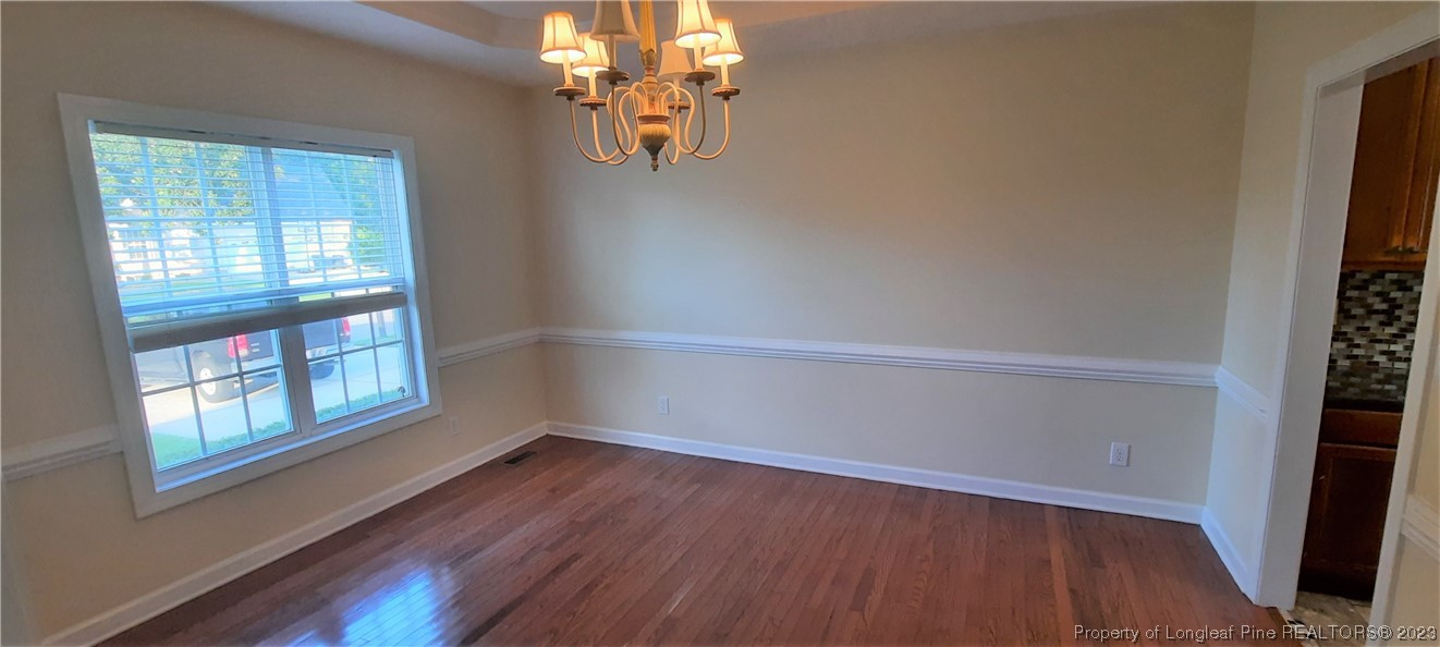 3513 Talus Road Fayetteville, NC 28306 - Photo 6 of 37 an empty room with wooden floor and windows