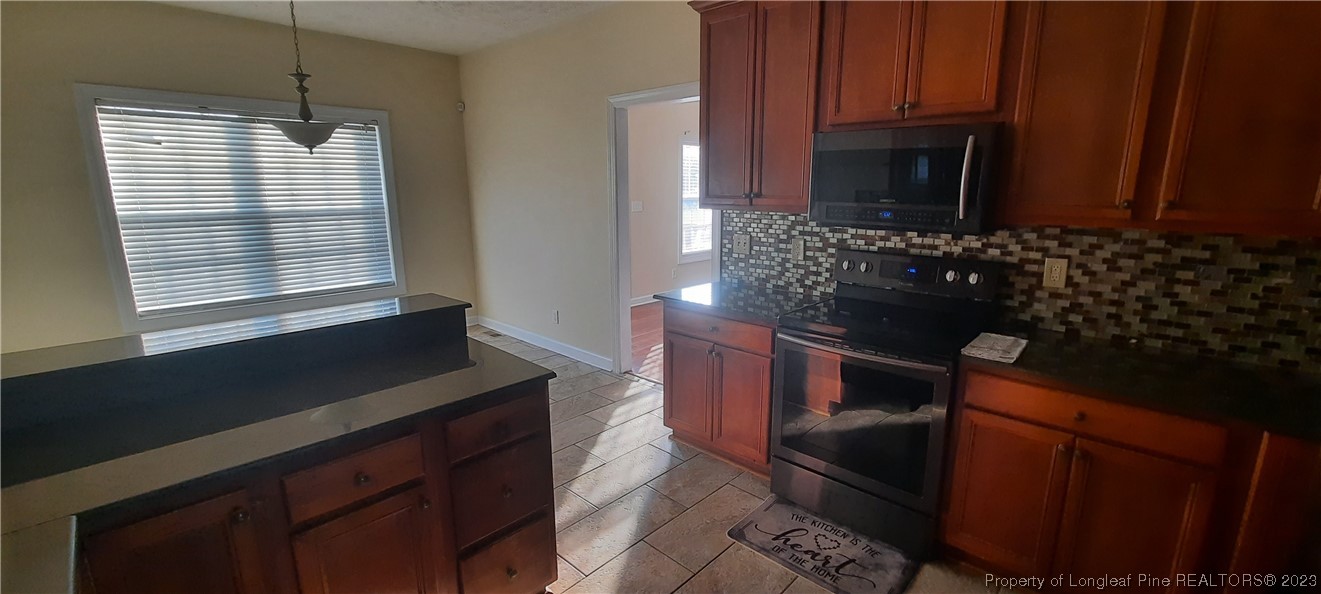 3513 Talus Road Fayetteville, NC 28306 - Photo 9 of 37 a kitchen with a sink stove and microwave
