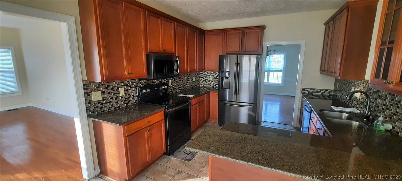3513 Talus Road Fayetteville, NC 28306 - Photo 10 of 37 a kitchen with stainless steel appliances granite countertop a refrigerator and a stove