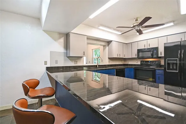 a kitchen with stainless steel appliances granite countertop a sink a stove and a microwave