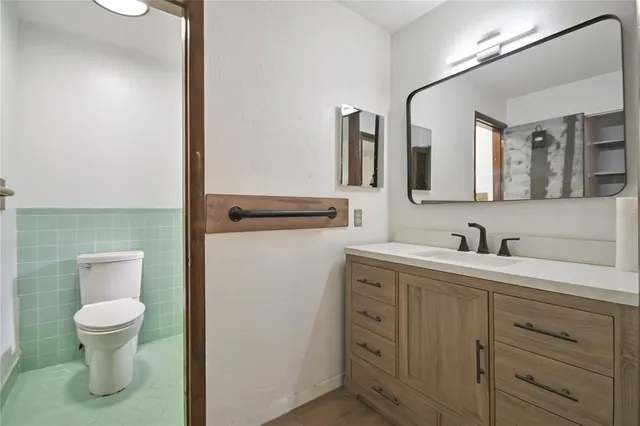 a spacious bathroom with a toilet sink and mirror