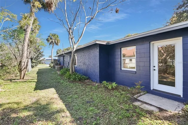 a brick house with a yard plants and brick wall