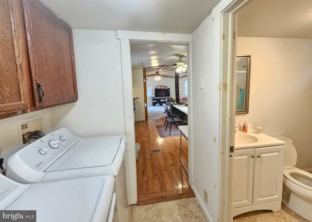 a view of a bedroom with baby crib and refrigerator