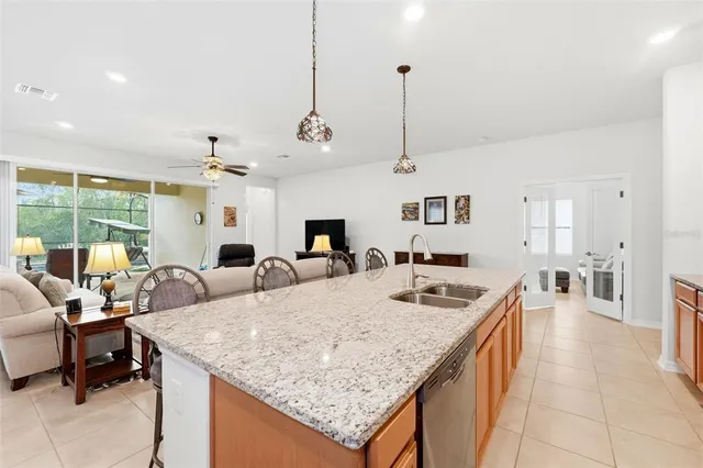 a view of a kitchen with kitchen island a counter top space a sink stainless steel appliances and cabinets