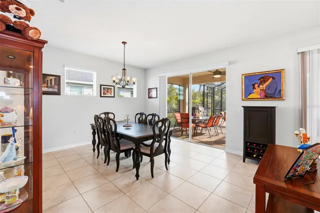 a view of a dining room with furniture a chandelier and a window