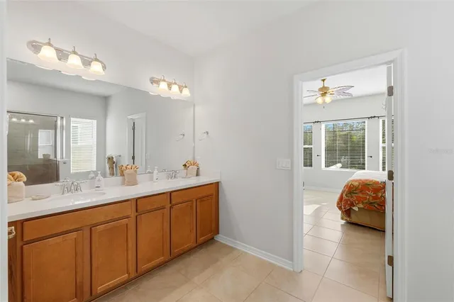 a en suite bathroom with a double vanity sink a mirror and a bathtub