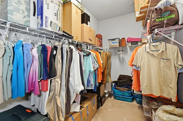 a view of walk in closet with clothes