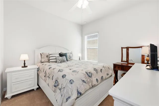 a bedroom with a bed and a flat tv screen on a dresser