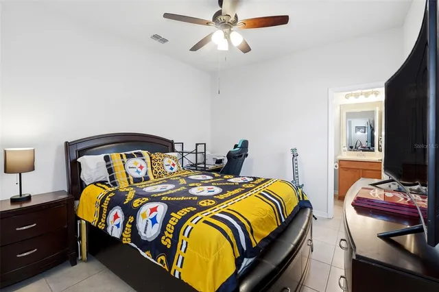 a bedroom with a bed and a flat tv screen on dresser