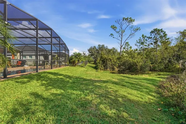 a view of a house with a big yard and large trees