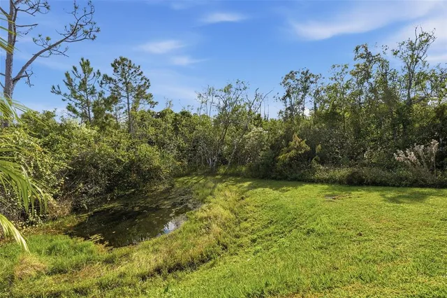 a front view of a house with a garden and lake view