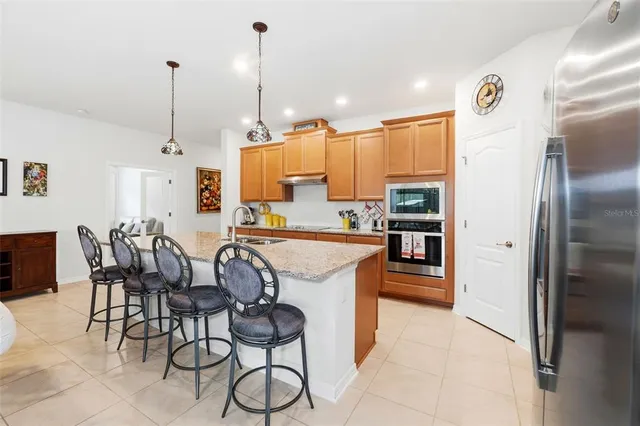 a kitchen with stainless steel appliances kitchen island granite countertop a refrigerator and microwave