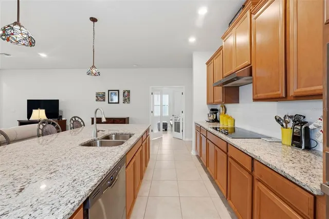 a kitchen with stainless steel appliances granite countertop a sink a counter top space cabinets and wooden floor