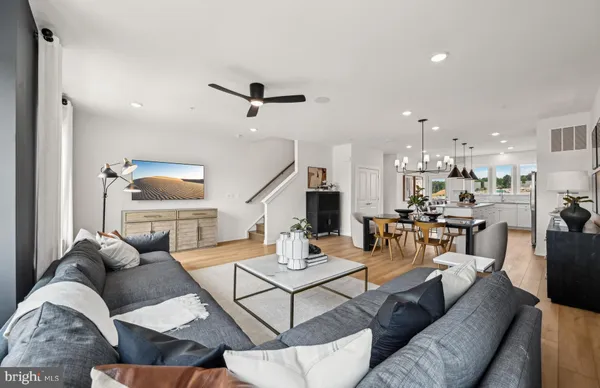 a living room with furniture and a view of kitchen
