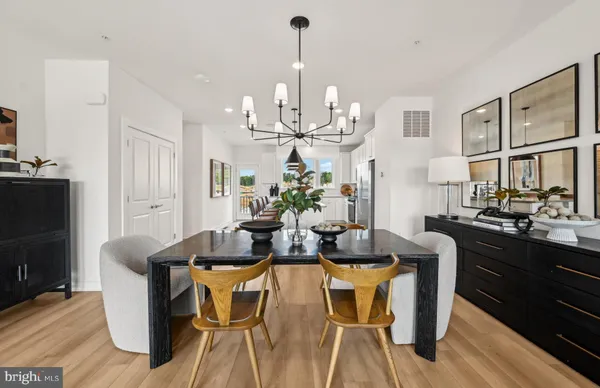 a view of a dining room with furniture a kitchen and chandelier