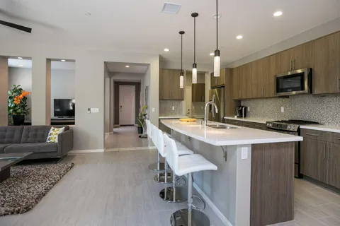 a kitchen with kitchen island granite countertop a sink and a refrigerator