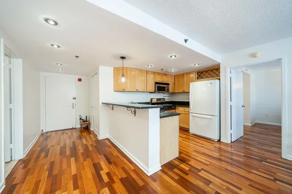 a kitchen with stainless steel appliances granite countertop a stove top oven a sink and a refrigerator