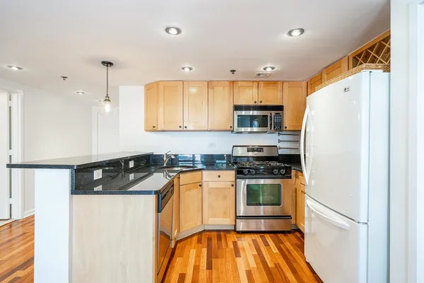 a large kitchen with cabinets wooden floor and a sink