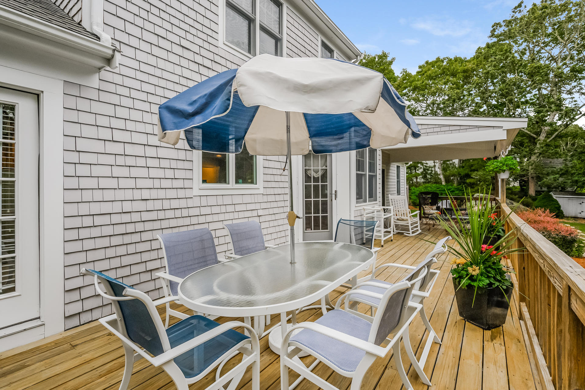 112 Cairn Ridge Road East Falmouth, MA 02536 - Photo 23 of 31 a view of a patio with table and chairs potted plants with wooden floor and fence
