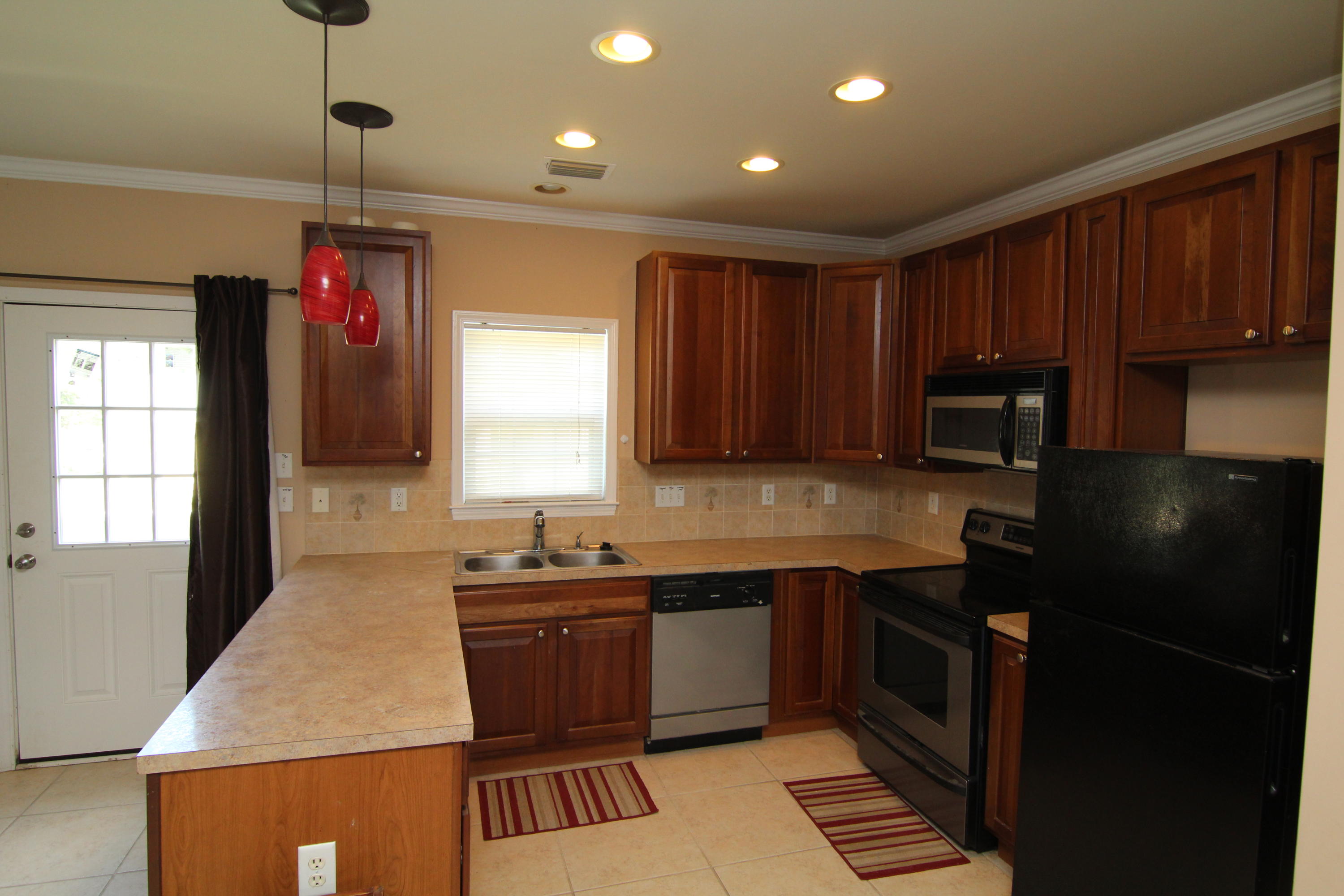 161 6th Street Santa Rosa Beach, FL 32459 - Photo 4 of 13 a kitchen that has a sink stainless steel appliances cabinets and a window