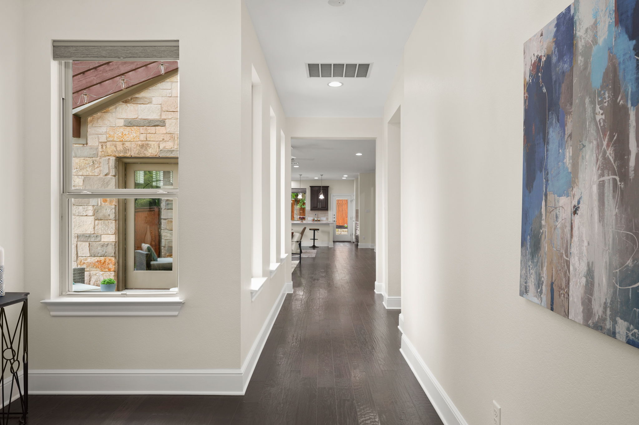 440 Cherokee Rose Circle Georgetown, TX 78626 - Photo 11 of 39 A refined corridor showcasing sleek dark hardwood floors and crisp white walls.