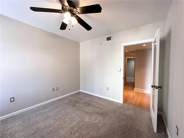 an empty room with closet and windows