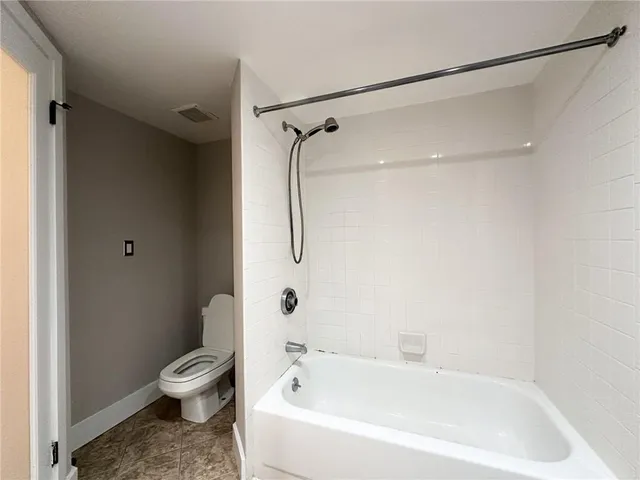 a white bath tub sitting next to a toilet