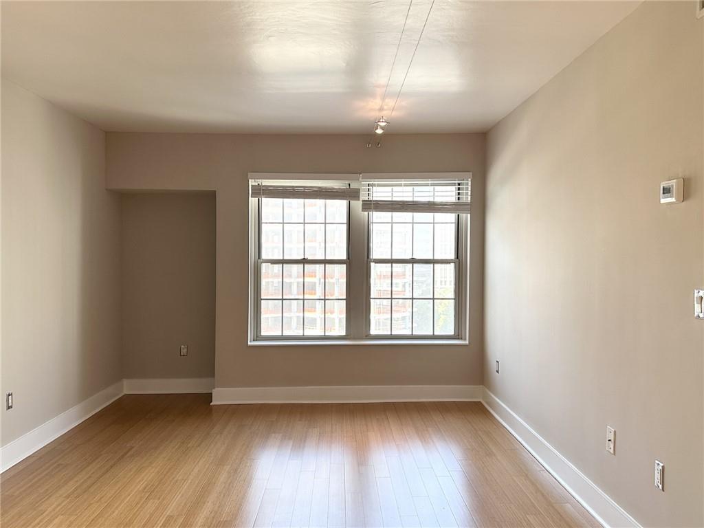199 14th Street Northeast, Unit 1609 Atlanta, GA 30309 - Photo 3 of 22 an empty room with wooden floor and windows