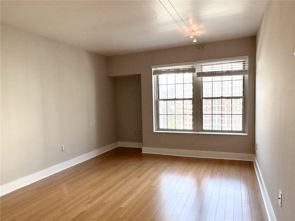 199 14th Street Northeast, Unit 1609 Atlanta, GA 30309 - Photo 5 of 22 an empty room with wooden floor and windows