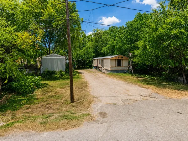 a view of a house with backyard and trees