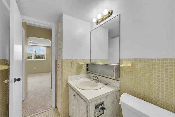 a bathroom with a sink toilet and mirror