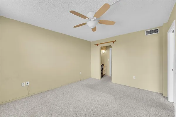 an empty room with closet and ceiling fan