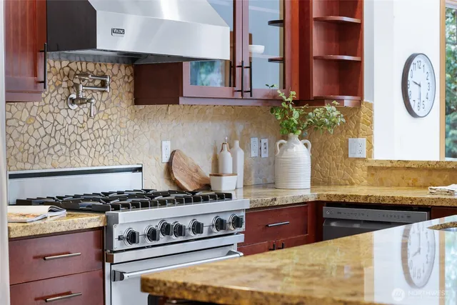 a kitchen with stainless steel appliances granite countertop a stove and a sink