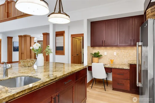 a kitchen with granite countertop a table chairs stove and refrigerator