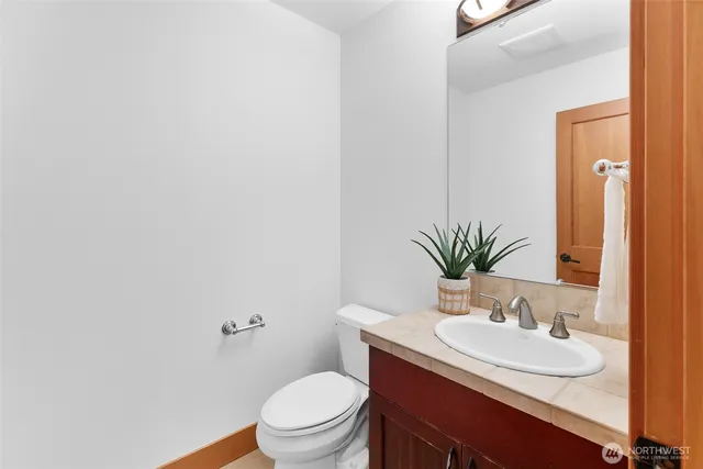 a bathroom with a granite countertop sink and a mirror with toilet