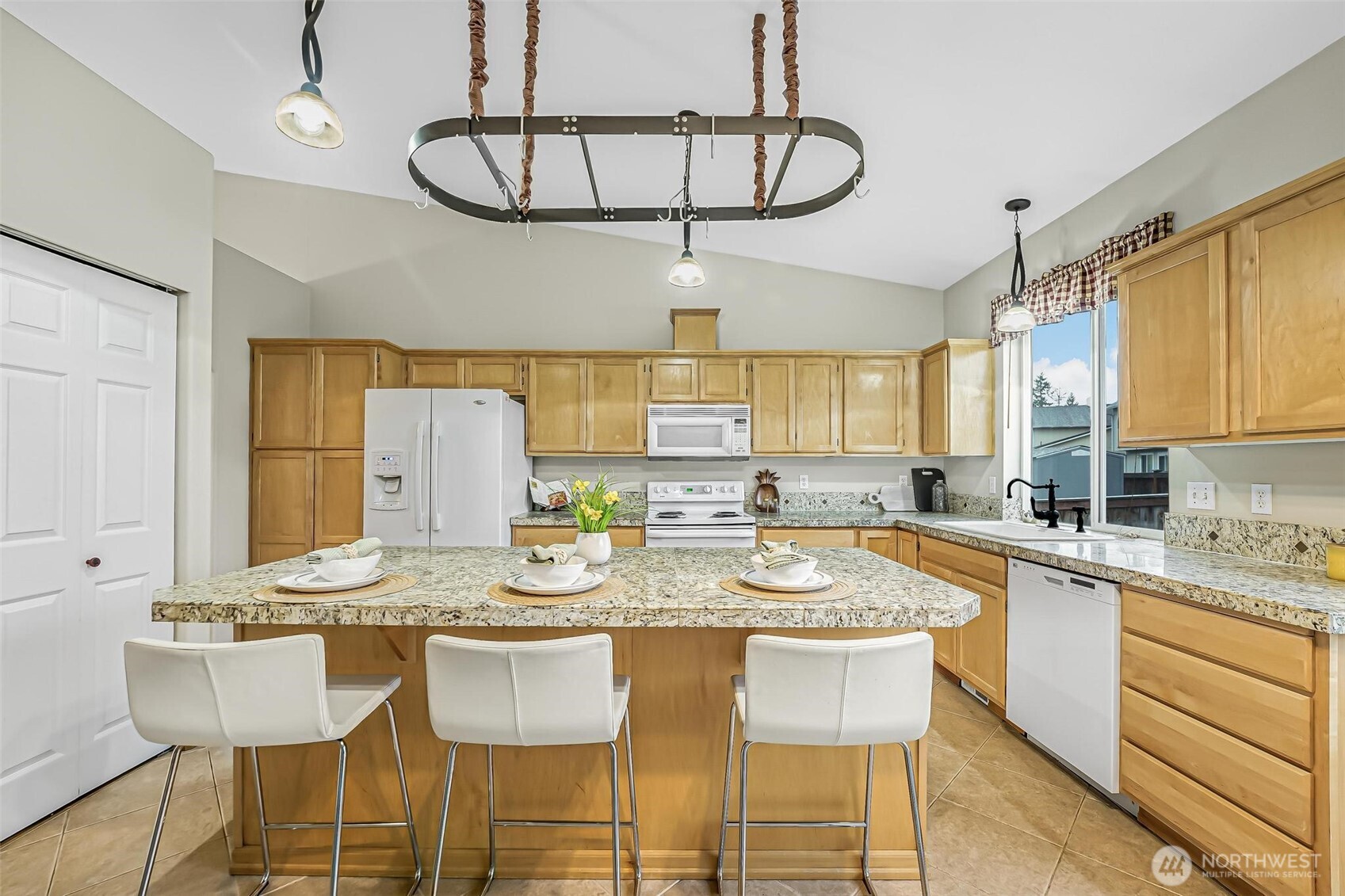 21012 Springhaven Way East Bonney Lake, WA 98391 - Photo 13 of 39 a kitchen with a dining table chairs and white cabinets